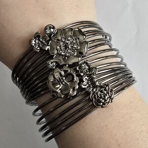 Floral bracelet multiple bangles joined by a focal piece with flowers silver ton